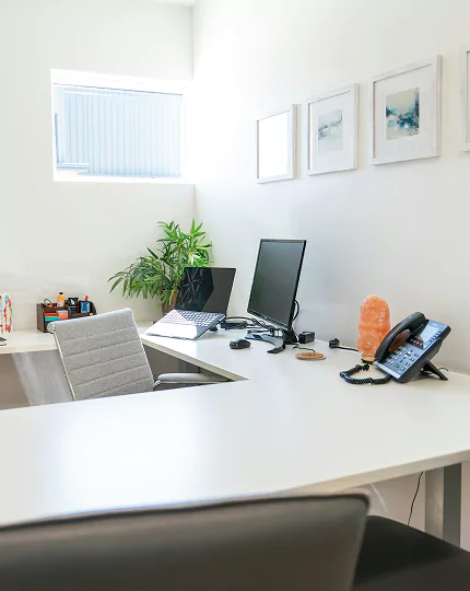 A tidy office featuring a desk with a computer, showcasing a professional and organized workspace.